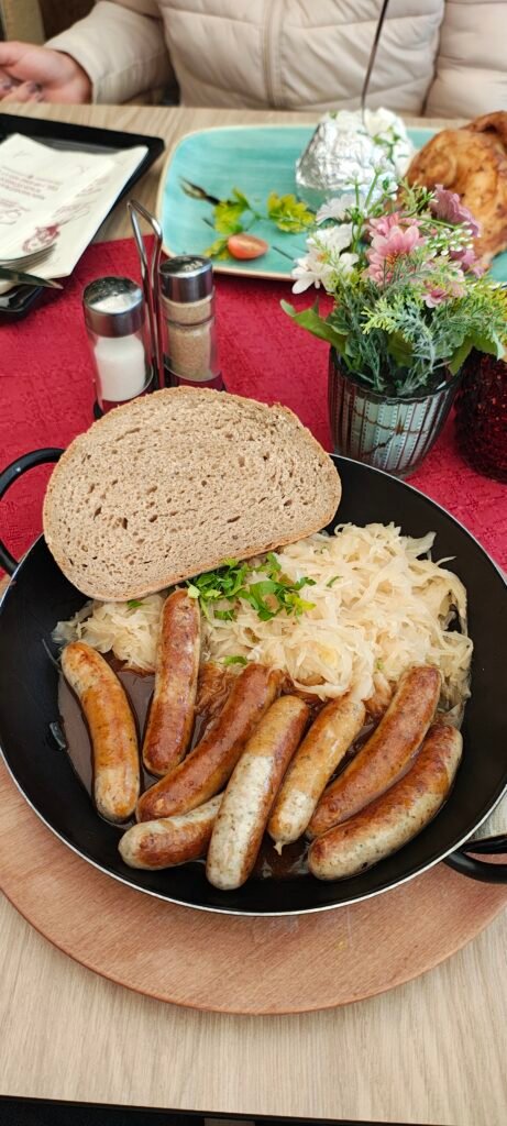Salsichas alemãs com chucrute – prato típico da Baviera Prato típico da Baviera com salsichas alemãs, chucrute e pão de centeio